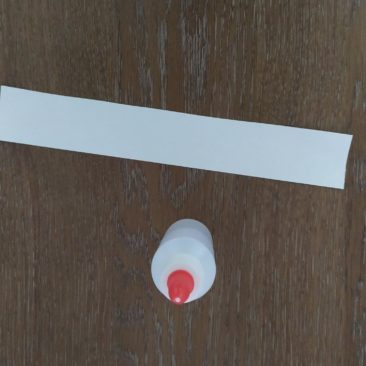 Mettre de la colle sur la bande de papier, puis coller la bande de papier autour du pot. Pour bien cacher jusqu’en bas, vous pouvez faire un tour de scotch sur le bas du pot.